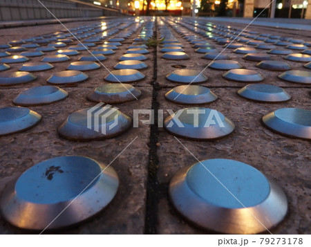 歩道のステンレス製のラウンドドット触覚インジケーターをかっこよく撮影しました。 歩道のステンレス製のラウンドドット触覚インジケーターをかっこよく撮影しました。 79273178