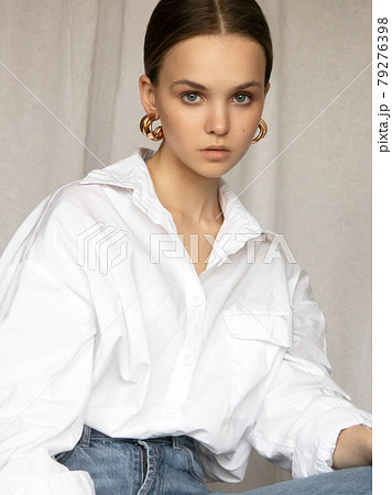 Beautiful female model . Beauty woman . Model test portrait with fashion girl in shirt and jeans on a textile background. Natural makeup and wavy hairstyle Beautiful female model . Beauty woman . Model test portrait with fashion girl in shirt and jeans on a textile background. Natural makeup and wavy hairstyle 79276398
