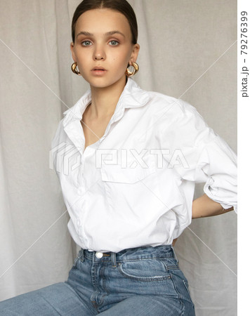 Beautiful female model . Beauty woman . Model test portrait with fashion girl in shirt and jeans on a textile background. Natural makeup and wavy hairstyle 79276399