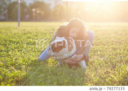 young girl play with her british bulldog at sunset 79277133