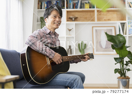 アコースティックギター持った笑顔の50代の男性 79277174