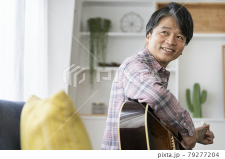 アコースティックギター持った笑顔の50代の男性 79277204