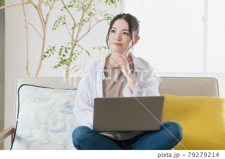 ソファに座ってテレワークする若い女性 79279214