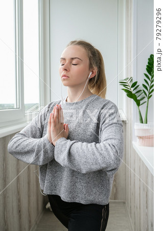 Young millennial blonde woman doing yoga exercise stretching