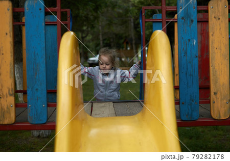 Happy little girl climbing on the big children playground at park toboggan Happy little girl climbing on the big children playground at park toboggan 79282178