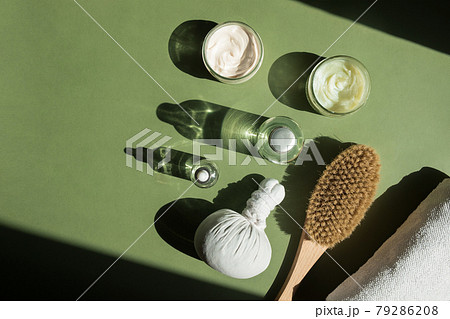 Body treatment and spa concept. Scrub, mask, cream and natural oil cosmetics on green background. Cellulite treatment, dry brushing. Womans cosmetic procedures 79286208