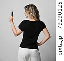 Blonde curly woman in black t-shirt and white 79290125