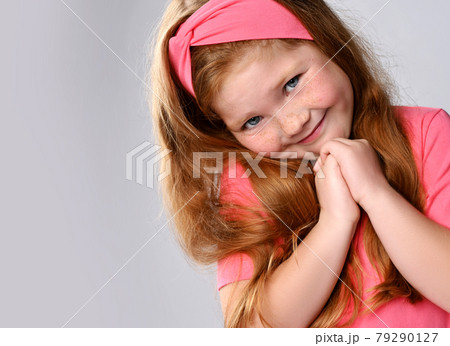 Portrait of cute, sly smiling redhead kid girl 79290127