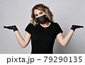 Blonde curly woman in black t-shirt, protective 79290135