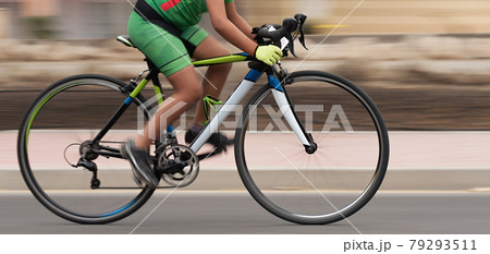 Cycling rider competing in the youth class, motion blur of a bike race with the bicycle and rider at high speed. Panning technique used Cycling rider competing in the youth class, motion blur of a bike race with the bicycle and rider at high speed. Panning technique used 79293511