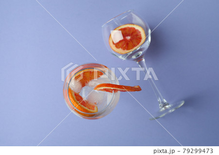 Glass of cocktail with grapefruit on violet background Glass of cocktail with grapefruit on violet background 79299473