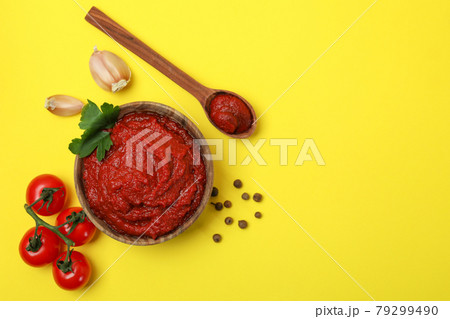 Bowl of tomato paste and ingredients on yellow background 79299490