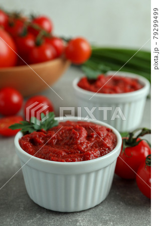 Bowls with tomato paste on gray background with ingredients Bowls with tomato paste on gray background with ingredients 79299499