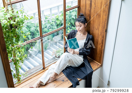 窓際で読書をする若い女性　 79299928