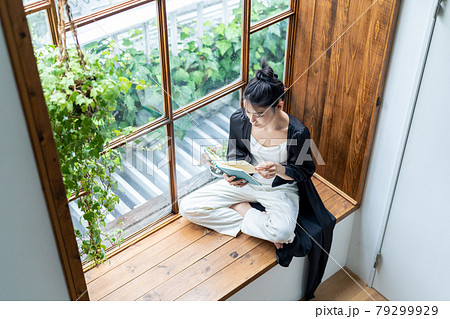 窓際で読書をする若い女性　 79299929
