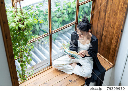 窓際で読書をする若い女性　 79299930