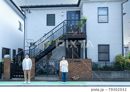新居の前に立つ新婚カップル 79302032