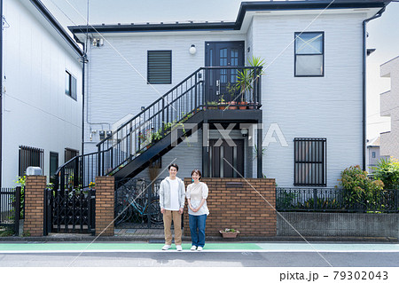 新居の前に立つ新婚カップル 79302043