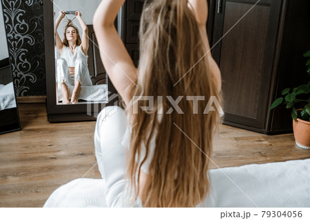 Mental health, mental wellbeing, calm, mourning routines, start day. No stress, healthy habit, concept. Young woman in pajamas waking up in morning, stretches in bed. Happy young girl greets new day. 79304056