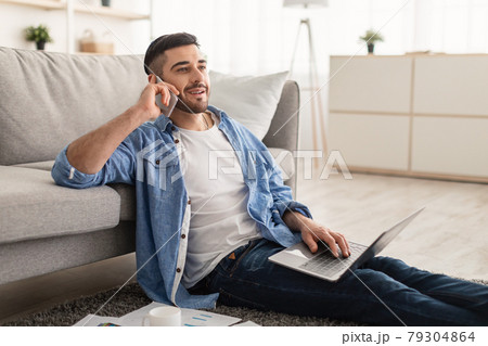 Smiling jew man working and talking on cellphone at home Smiling jew man working and talking on cellphone at home 79304864