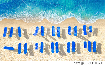 Empty blue sun beds on yellow sand beach, aerial panorama from directly above 79310371