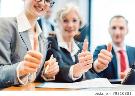 Business people showing thumbs up upon successful project 79310881