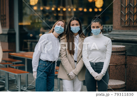 Happy friends looking at the camera wearing protective face mask Happy friends looking at the camera wearing protective face mask 79311830