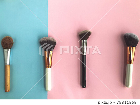 brushes on a pink-blue background. applying makeup, beauty with a natural base. using brushes to distribute powder, foundation, blush and highlighter brushes on a pink-blue background. applying makeup, beauty with a natural base. using brushes to distribute powder, foundation, blush and highlighter 79311868