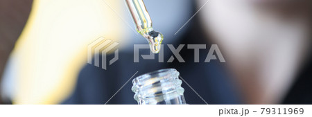 Pipette with drop is taken out of bottle with oil Pipette with drop is taken out of bottle with oil 79311969