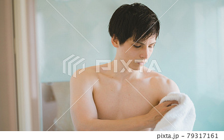 お風呂場で体を拭く若い男性 79317161