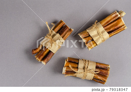 Bully sticks for dogs wrapped in brown paper and tied with twine 79318347