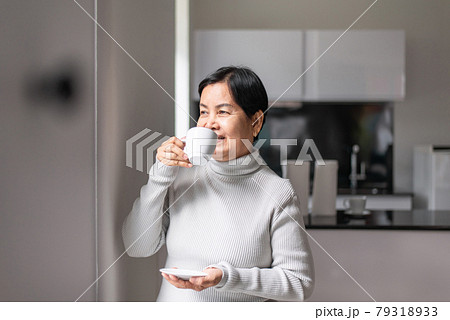 Mature asian woman drinking coffee near the window in the morning,Happy and smiling,Positive thinking,Health care senior insurance concept 79318933
