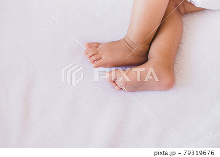Close up of little feet newborn baby lying on a comfortable bed at home Close up of little feet newborn baby lying on a comfortable bed at home 79319676