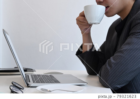Cropped shot businessman drinking coffee and reading email on laptop computer. 79321623