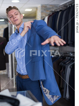 Portrait of man costumer trying jacket Portrait of man costumer trying jacket 79324733