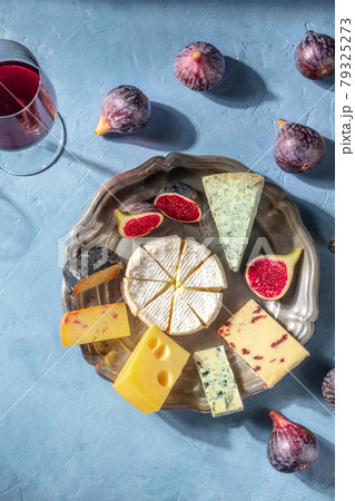 Cheese platter with fruit and a glass of red wine, shot from the top 79325273