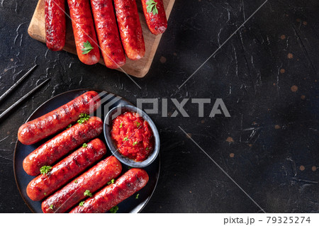 Sausages with ketchup, shot from the top on a black background 79325274