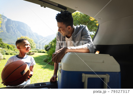 Happy african american father with son outdoors, preparing for picnic on sunny day 79327317