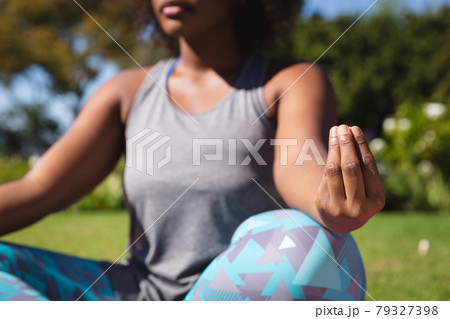 Midsection of african american woman practicing yoga in sunny garden Midsection of african american woman practicing yoga in sunny garden 79327398