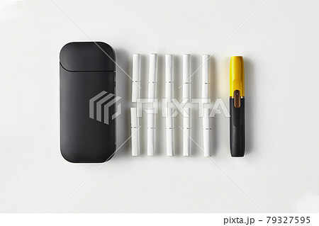 New generation black and yellow electronic cigarette, battery and ten heatsticks isolated on white. New technology. Heating tobacco system. Close up New generation black and yellow electronic cigarette, battery and ten heatsticks isolated on white. New technology. Heating tobacco system. Close up 79327595