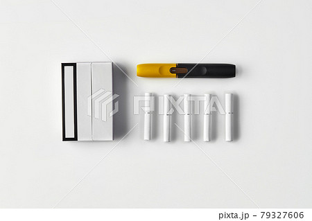 New generation black and yellow electronic cigarette, one pack and five heatsticks isolated on white. New technology. Heating tobacco system. Close up New generation black and yellow electronic cigarette, one pack and five heatsticks isolated on white. New technology. Heating tobacco system. Close up 79327606