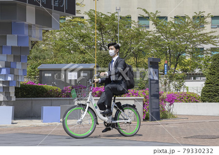Asian young man with mask riding sharing bicycle on the way tro work 79330232