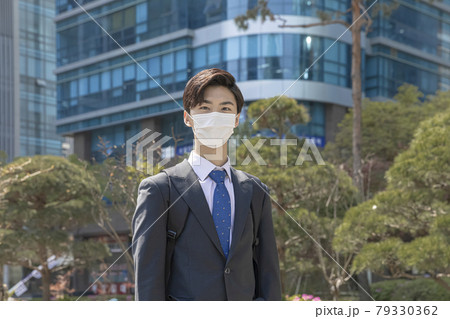 smiling handsome Asian man employee with mask on street smiling handsome Asian man employee with mask on street 79330362
