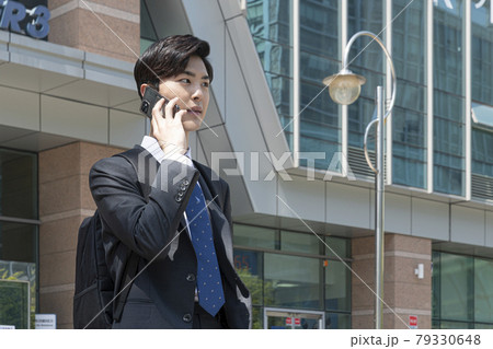 Asian man employee on smartphone, company building background Asian man employee on smartphone, company building background 79330648