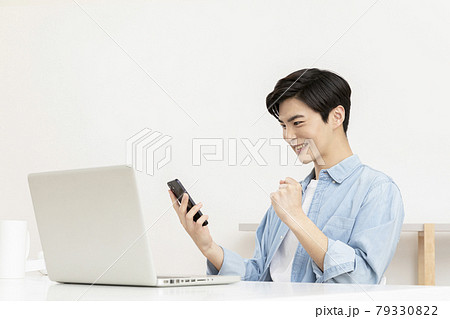 happy young Asian handsome man checking test, job result with laptop 79330822