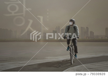 Asian delivery man riding bicycle in yellow dust Asian delivery man riding bicycle in yellow dust 79330920