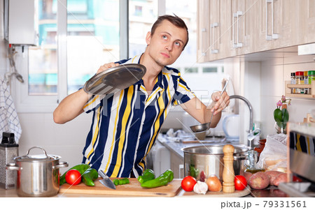 Ordinary man cooking soup in kitchen Ordinary man cooking soup in kitchen 79331561