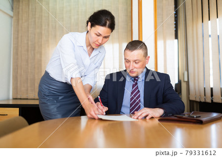 Business man and woman in office filling up documents 79331612