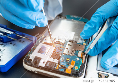 Technician repairing inside of mobile phone by soldering iron. Integrated Circuit. the concept of data, hardware, technology. 79331985