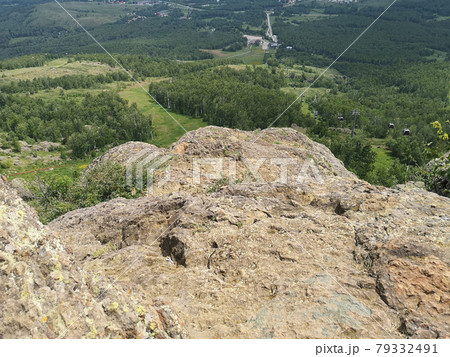 A large stone on the background of mountains with trees A large stone on the background of mountains with trees 79332491